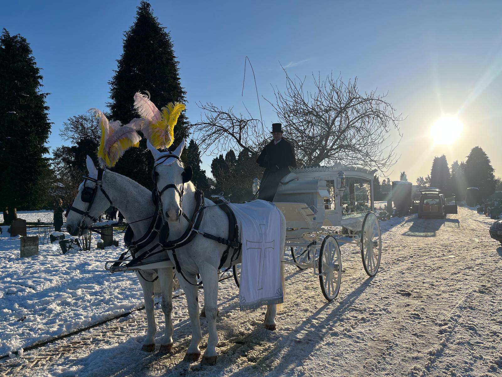 Traditional funeral director in top hat and long coat leading a cortege in Sittingbourne
